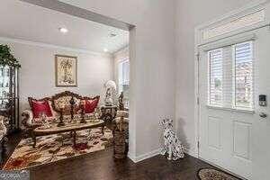 foyer entrance featuring breakfast area and crown molding