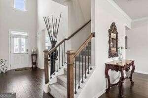 stairway with hardwood / wood-style flooring, plenty of natural light, and crown molding