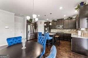 dining area with sink, crown molding, and a chandelier