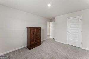 unfurnished bedroom with light carpet and a closet