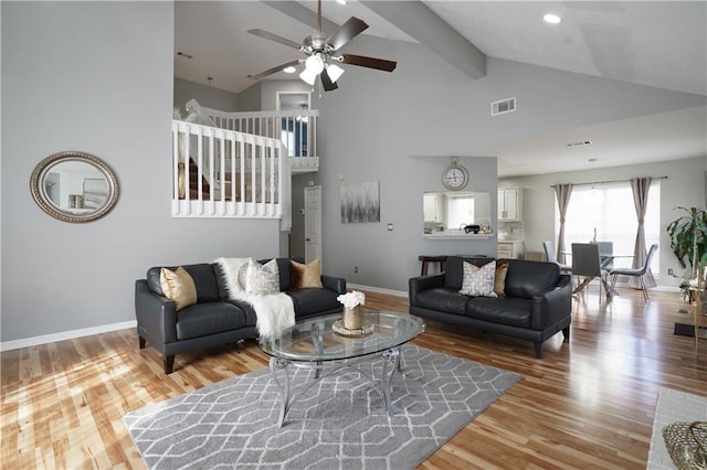 living room featuring hardwood / wood-style flooring, ceiling fan, high vaulted ceiling, and beam ceiling