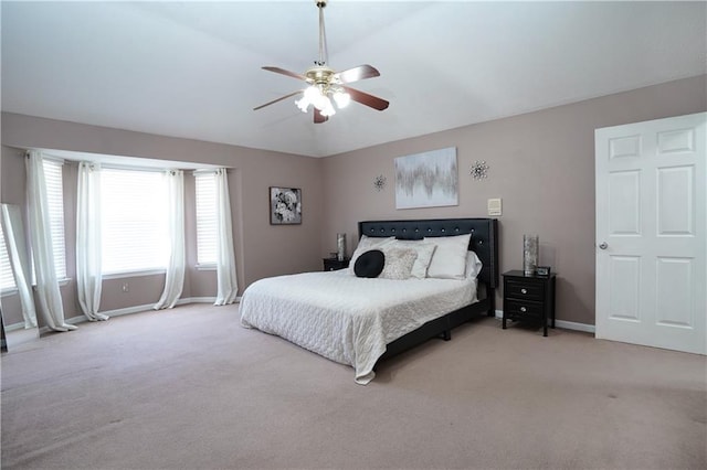 bedroom featuring lofted ceiling, light colored carpet, and ceiling fan