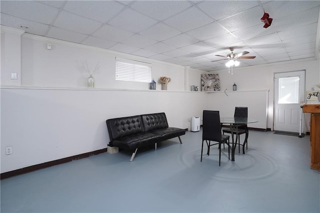 dining space featuring concrete flooring and a drop ceiling