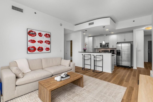 855 Peachtree St NE Unit 2706, Atlanta, GA 30308 - living room featuring visible vents, baseboards, and light wood finished floors