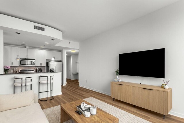 855 Peachtree St NE Unit 2706, Atlanta, GA 30308 - living room with visible vents, baseboards, and light wood finished floors