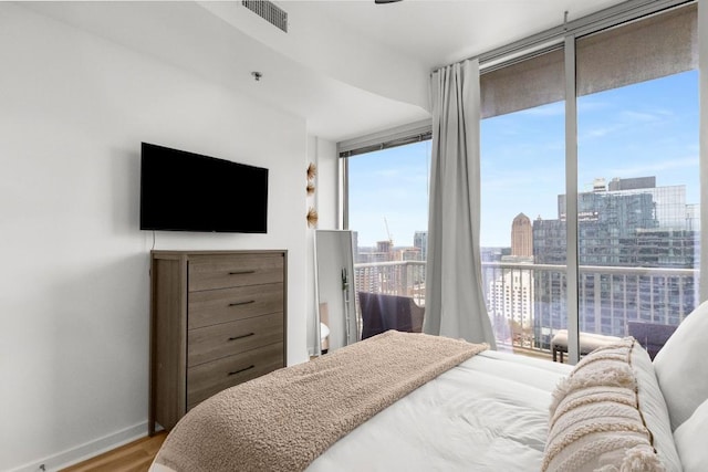 855 Peachtree St NE Unit 2706, Atlanta, GA 30308 - bedroom featuring expansive windows, visible vents, baseboards, and wood finished floors