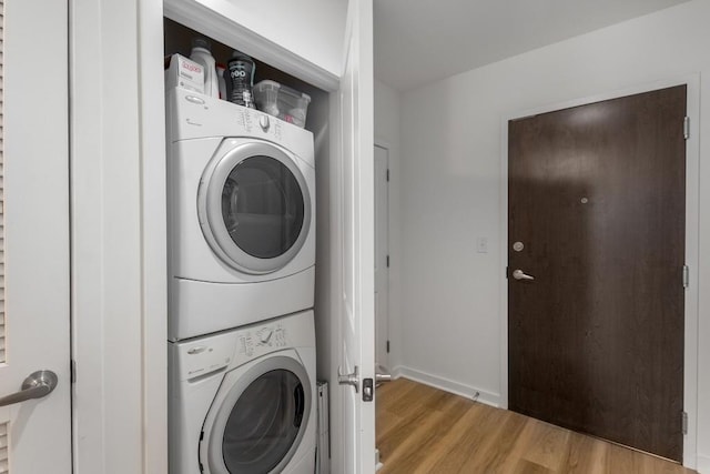 855 Peachtree St NE Unit 2706, Atlanta, GA 30308 - laundry area with stacked washer and dryer, baseboards, light wood-type flooring, and laundry area