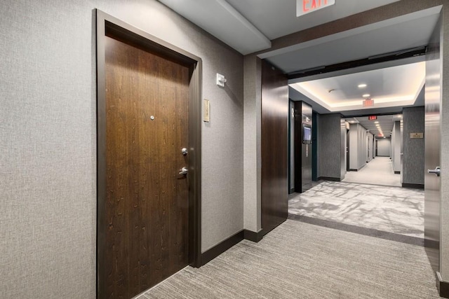 855 Peachtree St NE Unit 2706, Atlanta, GA 30308 - hall featuring a tray ceiling, light carpet, wallpapered walls, and baseboards