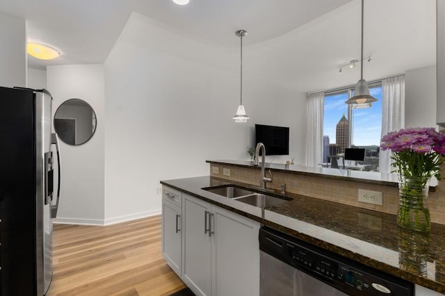 855 Peachtree St NE Unit 2706, Atlanta, GA 30308 - kitchen featuring dark stone countertops, hanging light fixtures, a sink, light wood-type flooring, and stainless steel appliances
