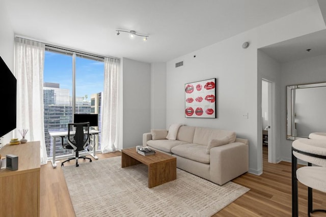 855 Peachtree St NE Unit 2706, Atlanta, GA 30308 - living area with light wood finished floors, visible vents, baseboards, and a wall of windows