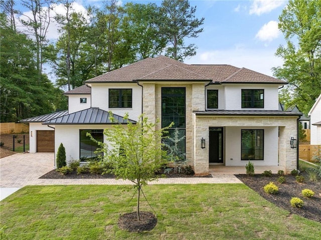 modern farmhouse featuring a garage, a front yard, and covered porch