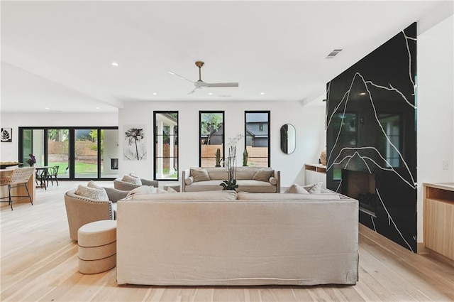 living room with ceiling fan and light wood-type flooring