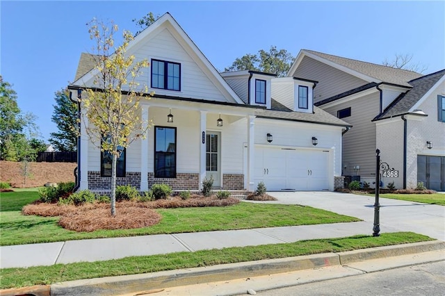 view of front of property with an attached garage, driveway, covered porch, and brick siding