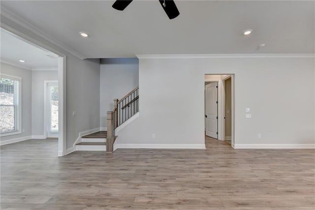 unfurnished living room with stairway, crown molding, light wood-style flooring, and ceiling fan