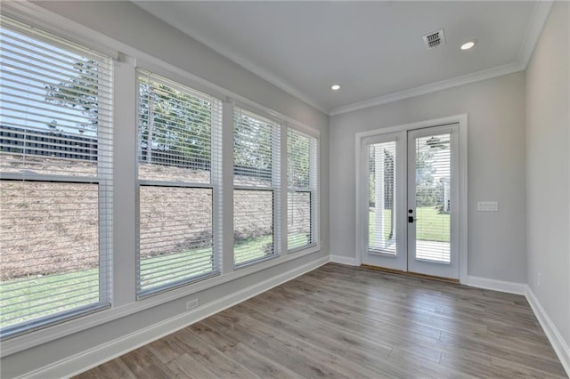 interior space featuring baseboards, ornamental molding, french doors, and wood finished floors