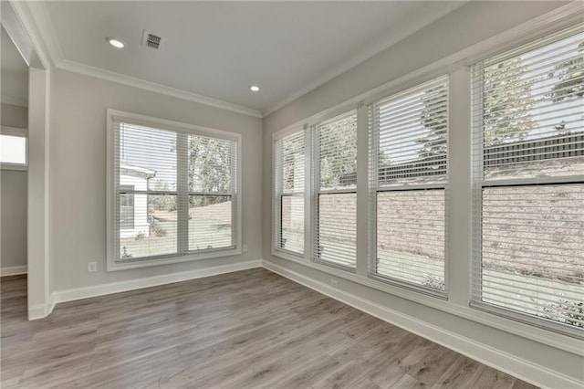 unfurnished sunroom with visible vents, baseboards, recessed lighting, wood finished floors, and ornamental molding
