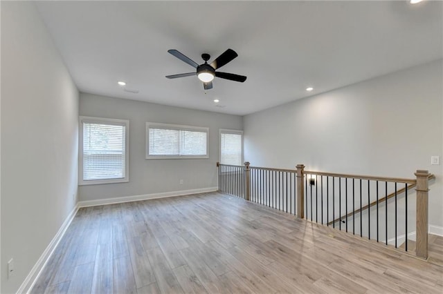 spare room featuring recessed lighting, wood finished floors, a ceiling fan, and baseboards