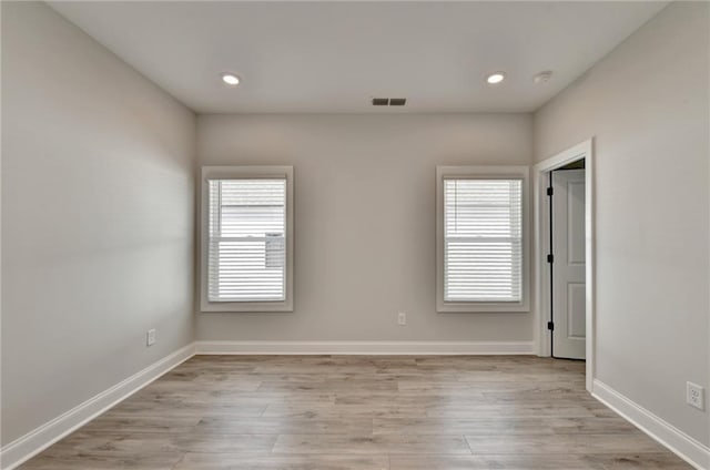 unfurnished room featuring recessed lighting, light wood-style flooring, visible vents, and baseboards