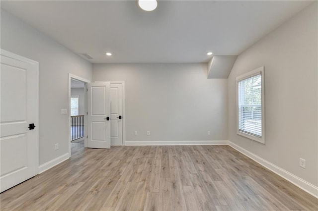 unfurnished room with light wood-type flooring, baseboards, and recessed lighting