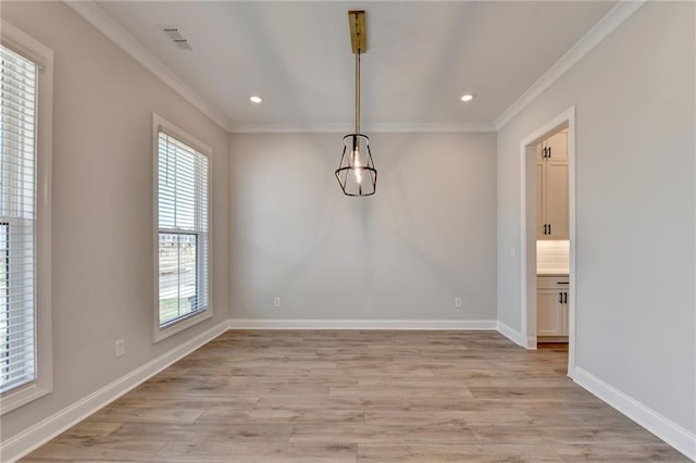 unfurnished dining area with light wood-type flooring, visible vents, baseboards, and ornamental molding