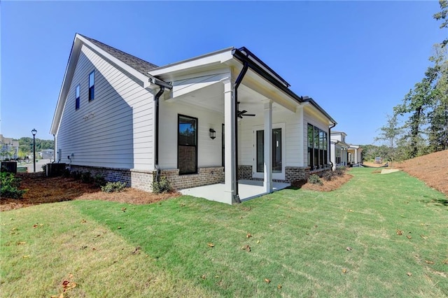 rear view of house with a lawn, a ceiling fan, and a patio