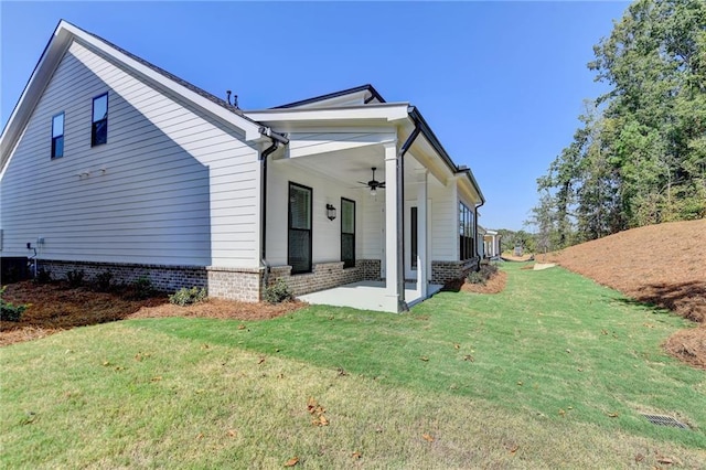 view of property exterior featuring a yard, a patio area, a ceiling fan, and cooling unit
