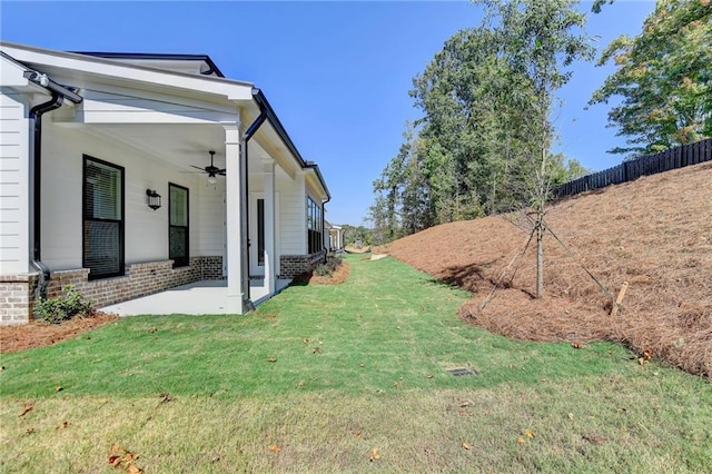 view of yard with fence, a patio area, and ceiling fan