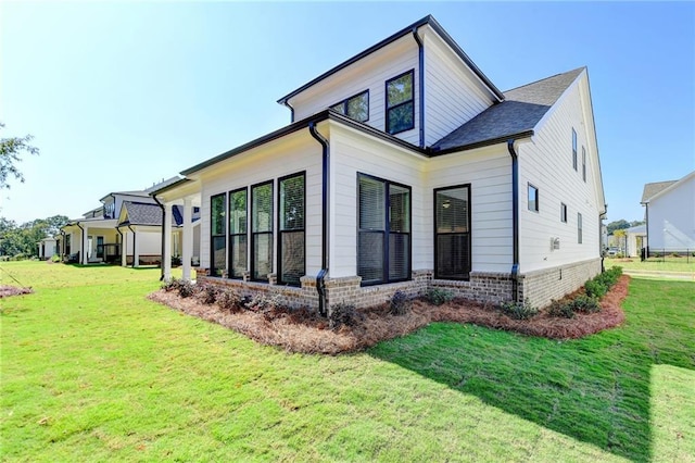 view of property exterior with a lawn and brick siding