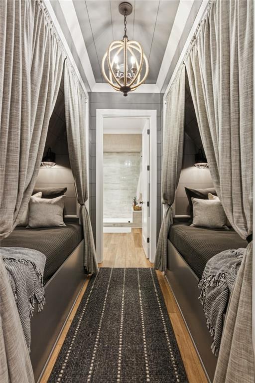 150 Trinity Farm Dr, Canton, GA 30115 - bedroom featuring wood finished floors, a chandelier, and a tray ceiling