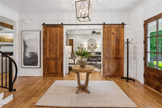 150 Trinity Farm Dr, Canton, GA 30115 - foyer with a barn door, wood finished floors, wood walls, ornamental molding, and stairs