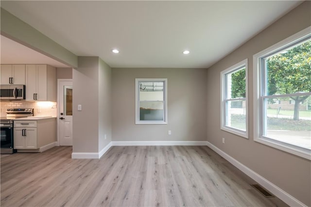 5961 John St, Austell, GA 30106 - kitchen with stainless steel appliances, healthy amount of natural light, white cabinets, light wood-style floors, and recessed lighting