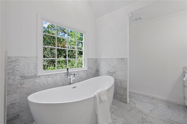 1017 Mill Creek Mnr NE, Brookhaven, GA 30319 - full bathroom with vanity, marble finish floors, a freestanding tub, a wainscoted wall, and tile walls