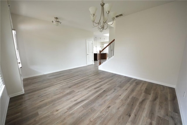 interior space with visible vents, dark wood-style floors, baseboards, a chandelier, and stairs