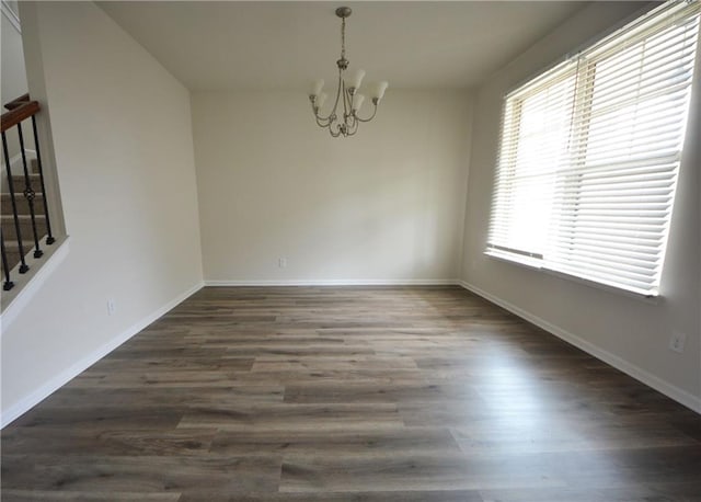 unfurnished room with dark wood finished floors, stairway, a notable chandelier, and baseboards