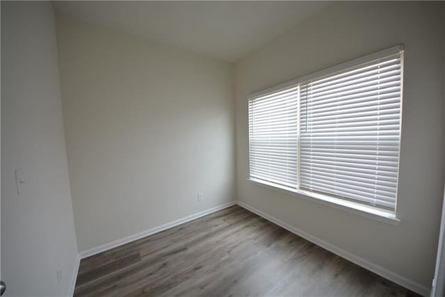 unfurnished room with baseboards and wood finished floors