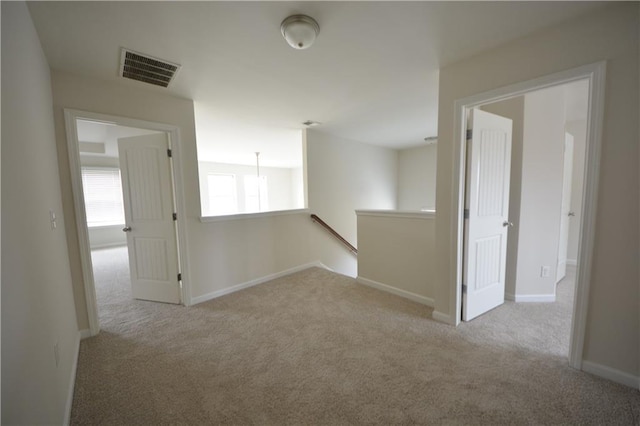 carpeted empty room with visible vents and baseboards