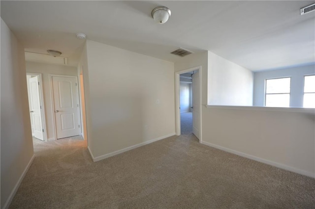 unfurnished room featuring visible vents, carpet flooring, and baseboards