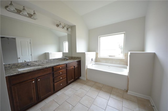 full bathroom featuring vaulted ceiling, a healthy amount of sunlight, and a sink