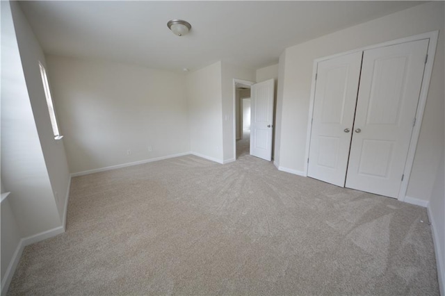 unfurnished bedroom featuring baseboards, a closet, and carpet floors