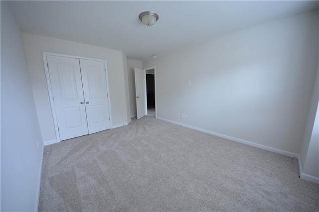 unfurnished bedroom featuring baseboards, a closet, and carpet floors