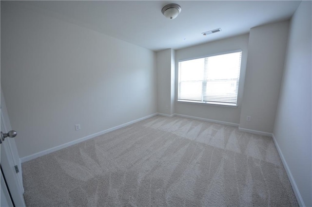 unfurnished room featuring light colored carpet, baseboards, and visible vents