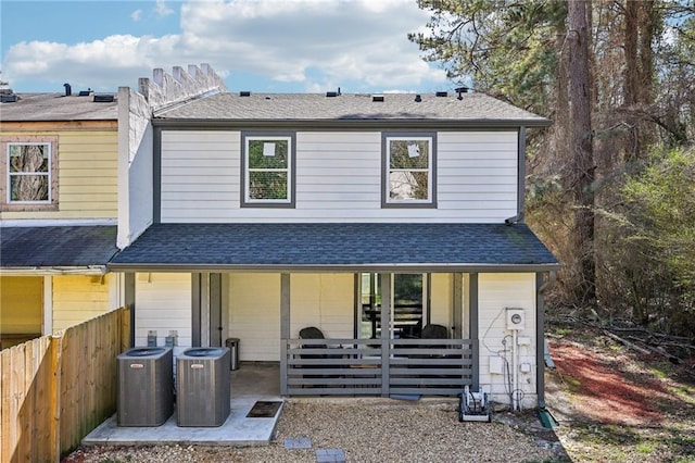 back of property featuring a shingled roof, fence, and cooling unit