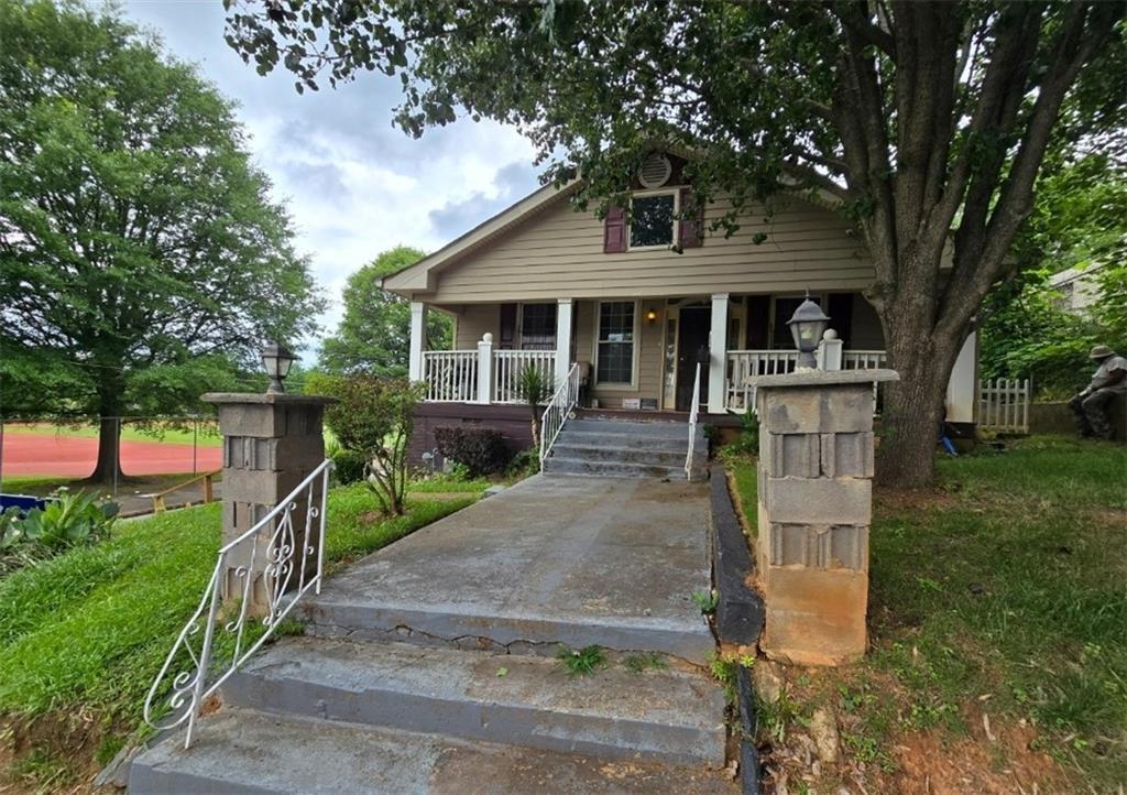 bungalow-style house with covered porch and a front lawn