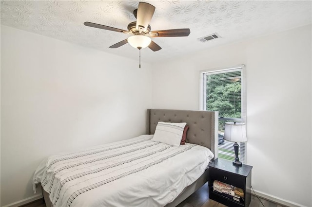 bedroom featuring a textured ceiling, ceiling fan, and hardwood / wood-style flooring