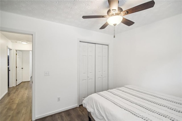 bedroom featuring ceiling fan, a closet, dark hardwood / wood-style flooring, and a textured ceiling