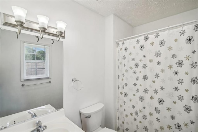 bathroom with toilet, vanity, a textured ceiling, and curtained shower