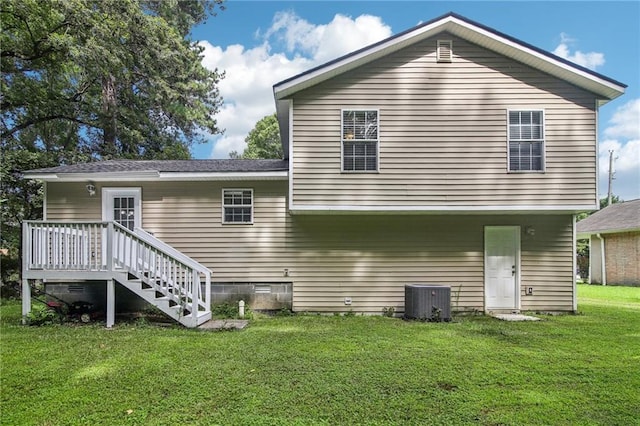 rear view of house featuring a deck, cooling unit, and a yard