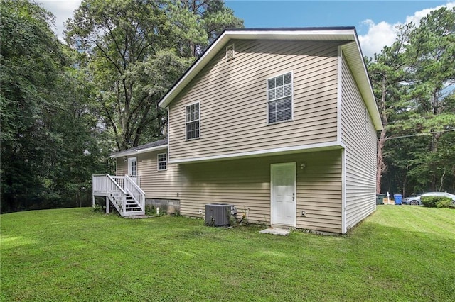 back of property featuring central AC unit, a deck, and a lawn