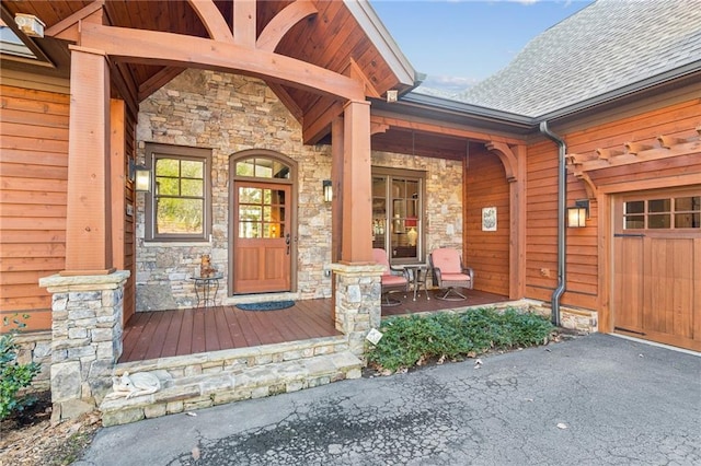 entrance to property featuring stone siding and a porch