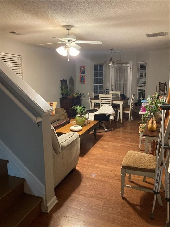 living room featuring hardwood / wood-style floors, a textured ceiling, and ceiling fan